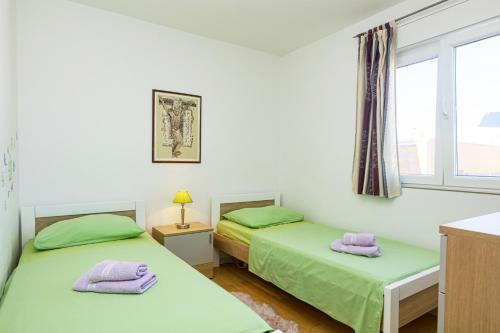 2 Einzelbetten in einem Zimmer mit Fenster in der Unterkunft Apartments by the sea Pirovac, Sibenik - 15659 in Pirovac