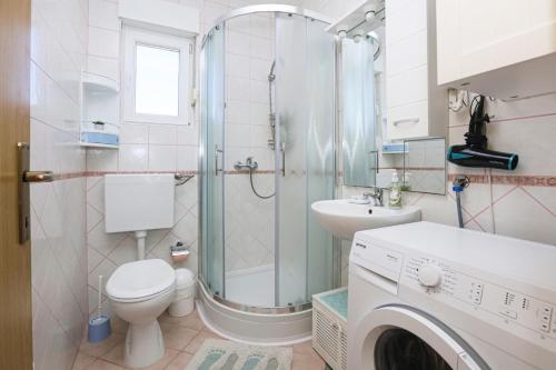 ein Bad mit einer Dusche, einem WC und einem Waschbecken in der Unterkunft Apartments by the sea Pirovac, Sibenik - 15659 in Pirovac