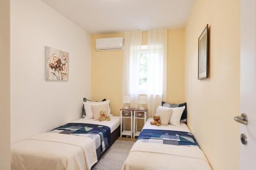 two beds in a small room with a window at Luxury villa with a swimming pool Poljica, Zadar - 22070 in Vrsi