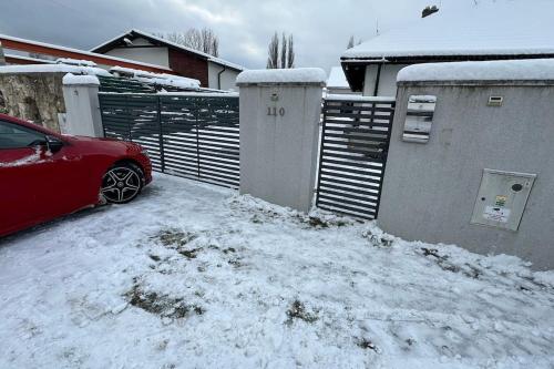 a red car parked in a yard covered in snow at Apartment house with sauna and jacuzzi Svätý Kríž 1 in Svätý Kríž