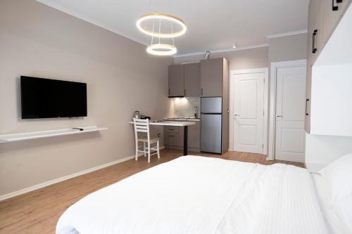 een slaapkamer met een bed en een bureau met een televisie bij Trio Apartment's City Center Tirana in Tirana