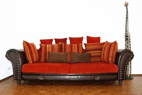 a red couch with pillows on top of it at Hostel Villa Viva in Bregenz