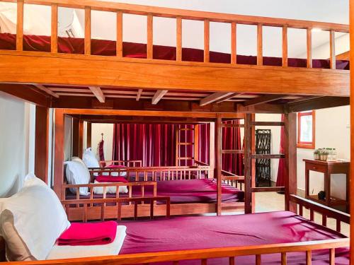 a bedroom with two bunk beds and a living room at Bamboo Bungalow in Kampot
