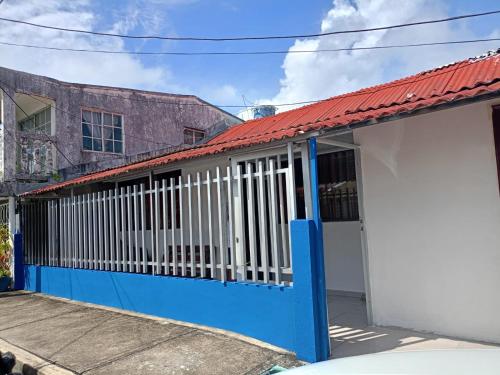 a blue and white house with a red roof at Donde missluz inn in San Andrés