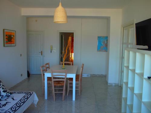 eine Küche und ein Esszimmer mit einem Tisch und Stühlen in der Unterkunft Pace 27 in Alghero