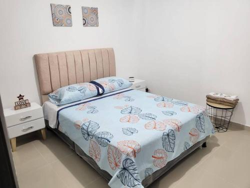 um quarto com uma cama com um edredão azul em ¡Hermoso y cómodo apartamento! em Ibagué