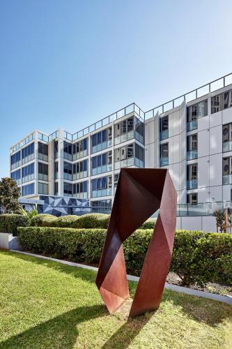 a sculpture in the grass in front of a building at Meriton Suites Bondi Junction in Sydney