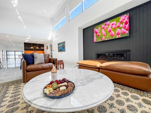 a living room with a table with a plate of food at Casa Divina in Pokolbin