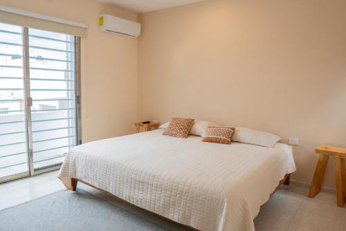 a bedroom with a bed and a large window at Amplia casa con 3 habitaciones para hospedaje in Chetumal