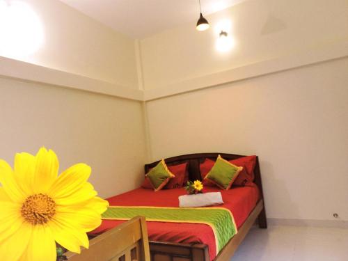 a small bedroom with a bed with a yellow flower at Kanna Garden by Bodhi Bungalows in Kolli Hills