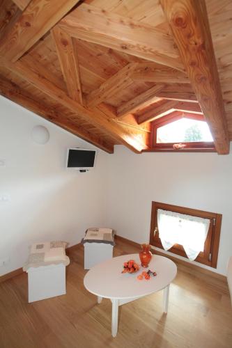 a living room with a white table and wooden ceilings at Albergo Diffuso Polcenigo D. Brolo in Polcenigo