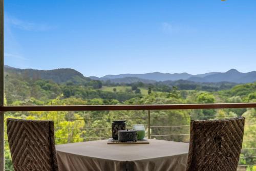 a table on a balcony with a view of mountains at La Rochér Eco Retreat in Stokers Siding
