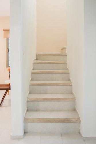 a staircase in a room with white walls at Amplia casa con 3 habitaciones para hospedaje in Chetumal
