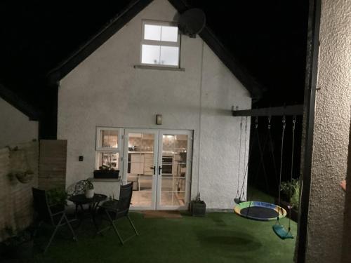 a house with a patio with a table and chairs at Ballinacross Lodge in Foyle Hill