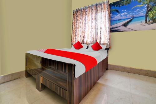 a bed with red pillows in a room at OYO Flagship Prakash Inn in Jamshedpur