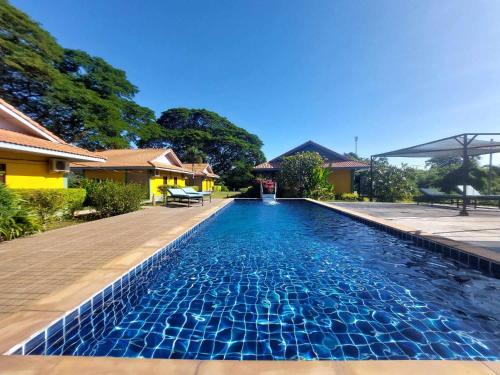 a swimming pool in front of a house at Khong Chiam Orchid Riverside Resort in Khong Chiam