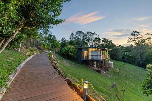a house on a hill with a wooden walkway at La Rochér Eco Retreat in Stokers Siding