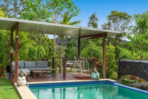 a swimming pool with a pergola next to a house at La Rochér Eco Retreat in Stokers Siding