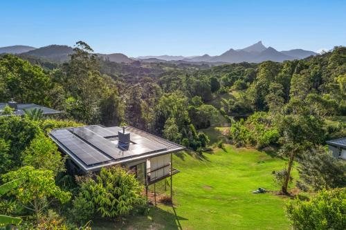 an aerial view of a house on a hill with green grass at La Rochér Eco Retreat in Stokers Siding