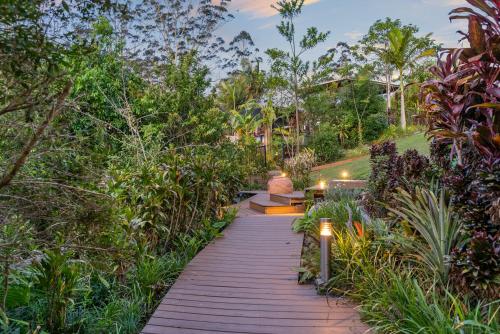 a wooden path through a garden with trees and plants at La Rochér Eco Retreat in Stokers Siding