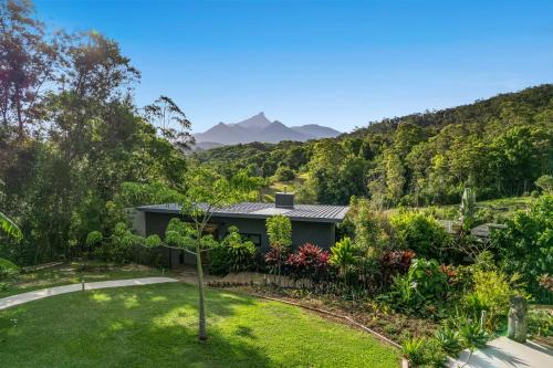 a house with a garden and mountains in the background at La Rochér Eco Retreat in Stokers Siding