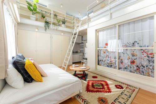 a room with a bed and a ladder and a window at M'sHouse in Tokyo