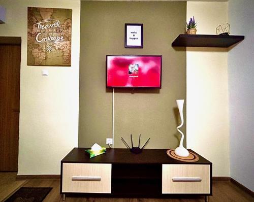 uma sala de estar com uma mesa e uma televisão na parede em ROOR Top Nest 3 em Gheorgheni