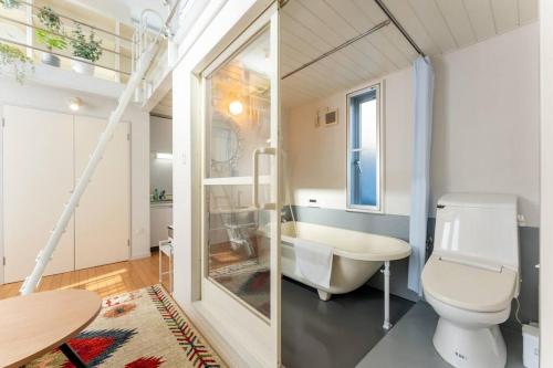 a bathroom with a toilet and a tub and a sink at M'sHouse in Tokyo