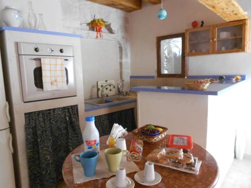 a small kitchen with a table and a stove at Piccola Azzurra in Comiso