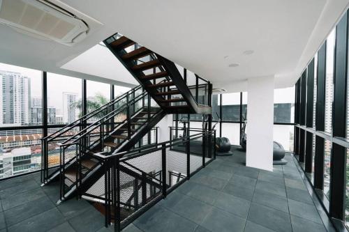 a spiral staircase in a building with windows at NEW Infinity Pool Seaview Urban Suite #2Carparks #2BR in Jelutong