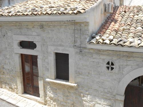 an old stone building with two windows and a roof at Piccola Azzurra in Comiso