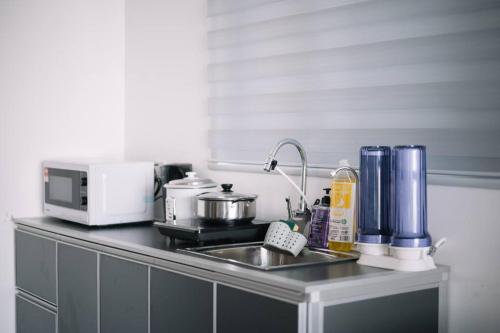 a kitchen counter with a sink and a microwave at NEW Infinity Pool Seaview Urban Suite #2Carparks #2BR in Jelutong