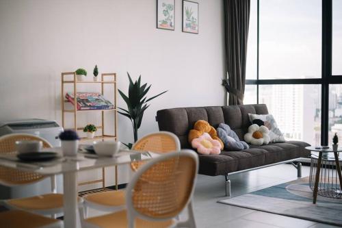 a living room with a couch with stuffed animals on it at NEW Infinity Pool Seaview Urban Suite #2Carparks #2BR in Jelutong