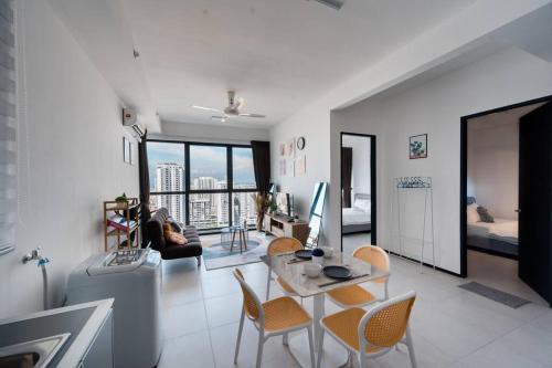 a living room with a table and chairs at NEW Infinity Pool Seaview Urban Suite #2Carparks #2BR in Jelutong