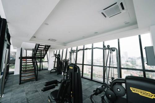 a gym with cardio equipment in a building with windows at NEW Infinity Pool Seaview Urban Suite #2Carparks #2BR in Jelutong