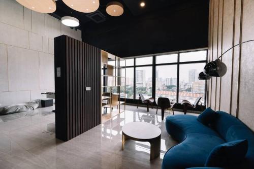 a living room with a blue couch and a table at NEW Infinity Pool Seaview Urban Suite #2Carparks #2BR in Jelutong