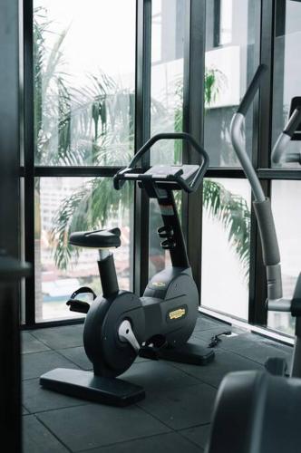 a gym with a exercise bike in front of a window at NEW Infinity Pool Seaview Urban Suite #2Carparks #2BR in Jelutong