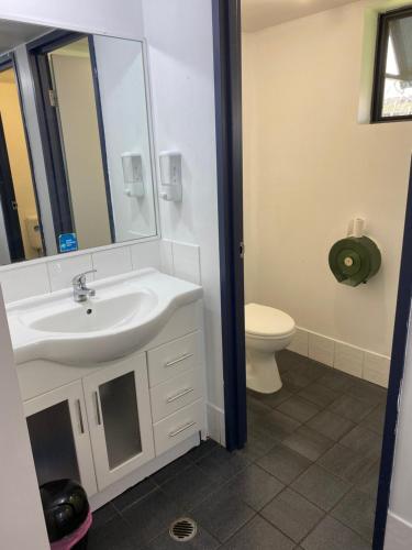 a bathroom with a sink and a toilet at Arrival Lodge Hostel Accommodation in Gold Coast