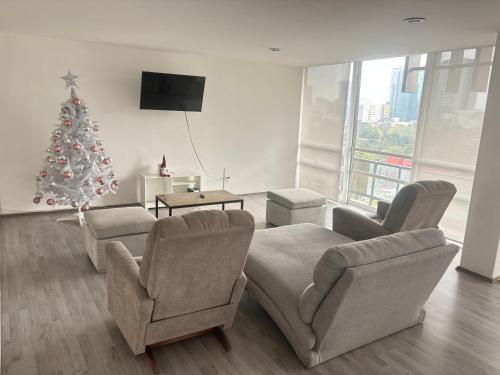 uma sala de estar com uma árvore de Natal e um sofá e cadeiras em bnb2night Polanco-Lomas em Cidade do México