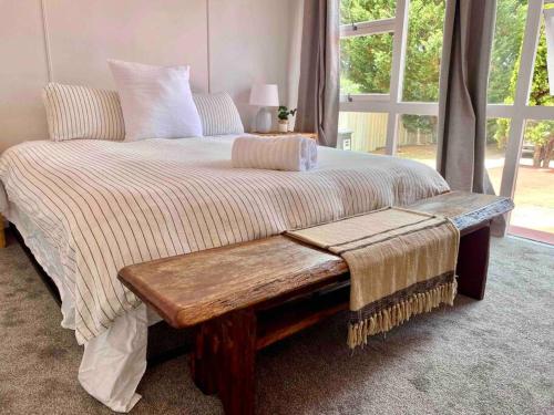 - un lit avec un banc en bois dans une chambre dans l'établissement Charming Mid Century Bungalow, à Stanthorpe