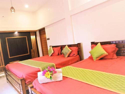 two beds in a room with red and green at Kanna Garden by Bodhi Bungalows in Kolli Hills