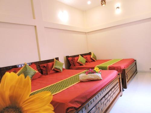 two beds in a room with a sunflower at Kanna Garden by Bodhi Bungalows in Kolli Hills