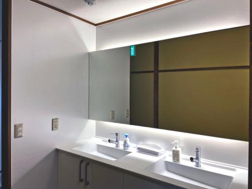 a bathroom with two sinks and a large mirror at Hanamizuki in Yamanakako