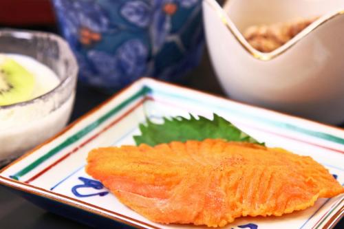 a piece of fish on a plate on a table at Hanamizuki in Yamanakako