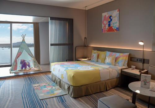 a bedroom with a large bed and a large window at Crowne Plaza Xiamen Jimei Seaview by IHG-Free Mini Bar in Xiamen