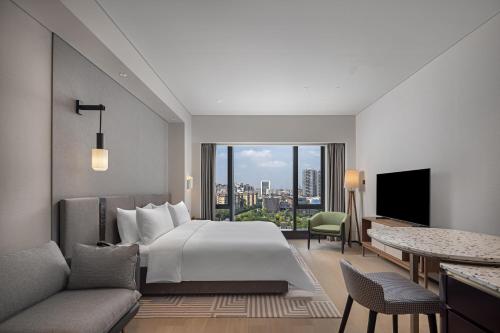 una camera d'albergo con letto e soggiorno di New World Guangzhou Hotel a Canton