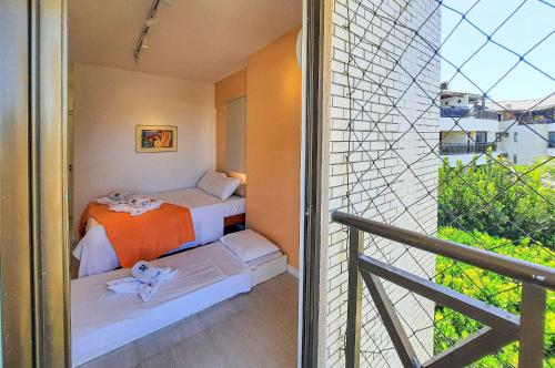 a small bedroom with two beds and a balcony at Cobertura Duplex 8 Pessoas Varanda Gourmet in Aquiraz