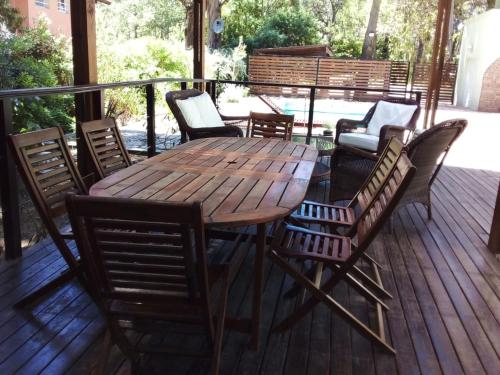 a wooden table and chairs on a deck at Casa en Cariló para 16 personas in Carilo