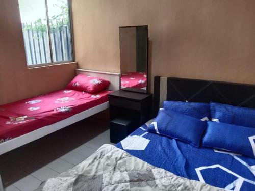 a room with two beds and a mirror and a bed at Nur Aisyah homestay kemaman..3 bedrooms in Kampong Kemaman