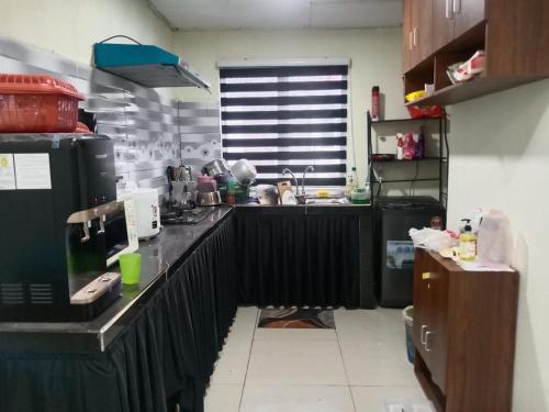 een keuken met een zwart aanrecht in een keuken bij Nur Aisyah homestay kemaman..3 bedrooms in Kampong Kemaman
